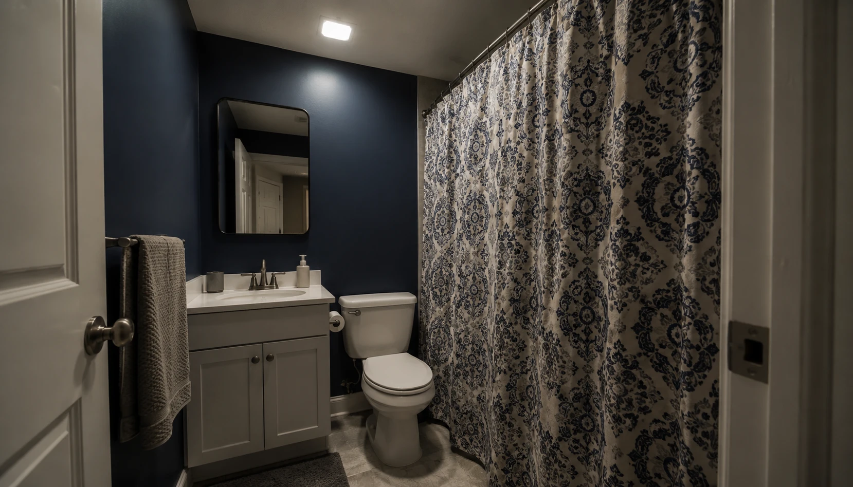 Cramped small bathroom with dark walls and heavy shower curtain showing common space-shrinking mistakes